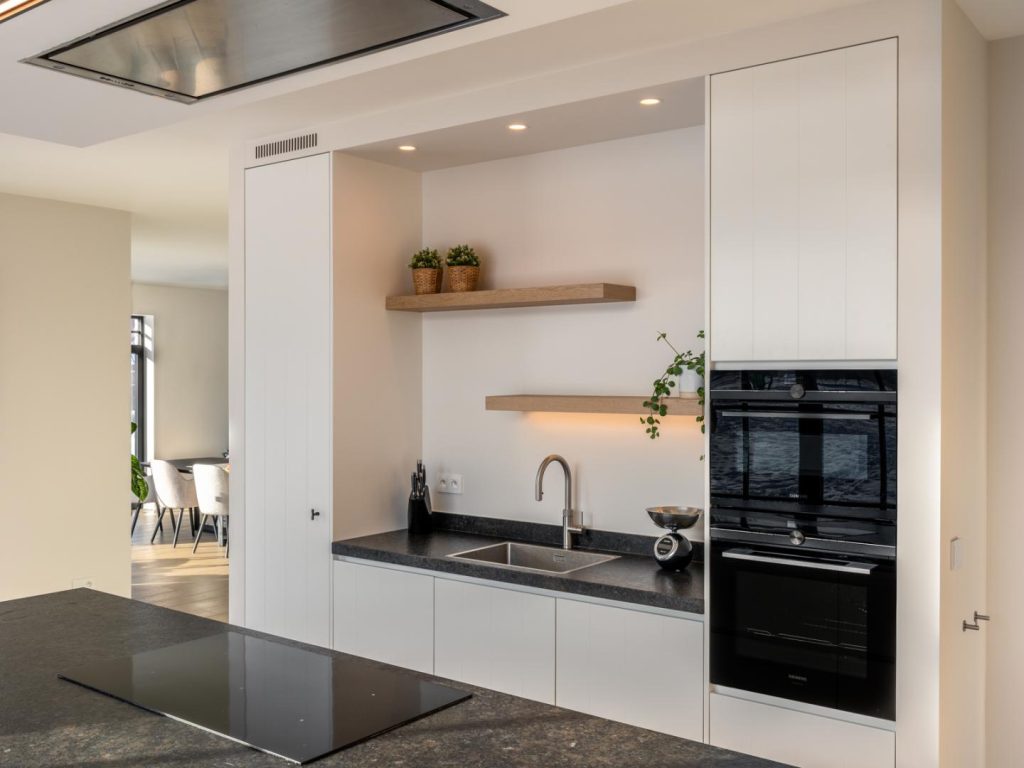 Leefkeuken in een mooi zwart-wit contrast, aangevuld met warme houten accenten